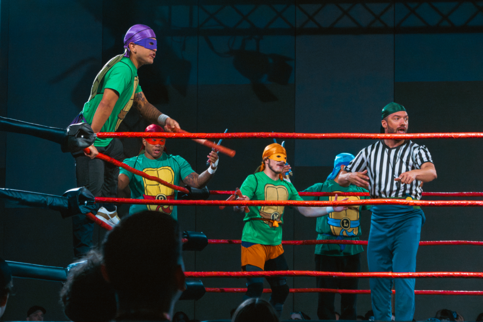 Ninja Turtle cosplayers facing the referee