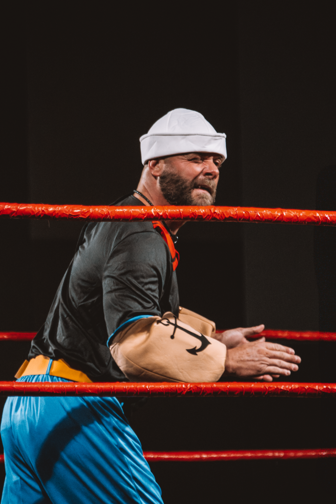 Popeye cosplayer flexing at ringside